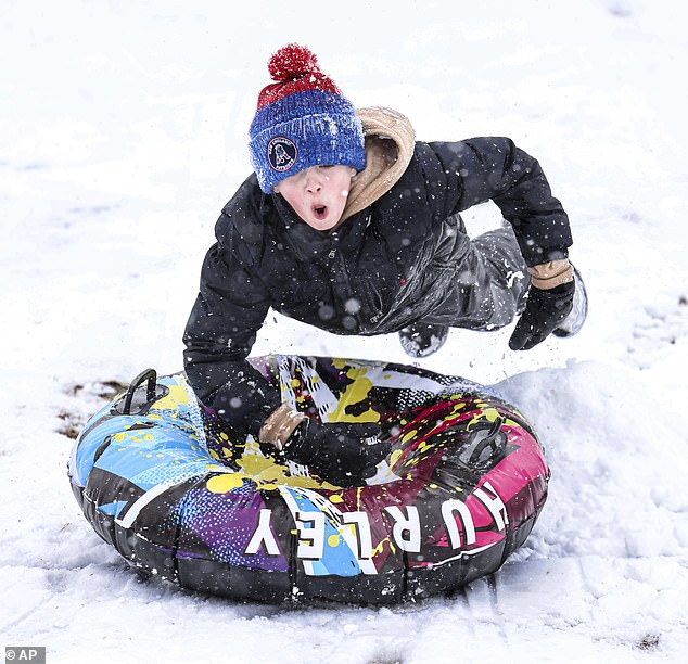 An 11-year-old boy gets some airtime Tuesday while sledding down a hill in North Attleborough, Massachusetts