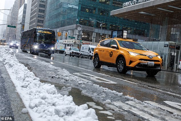 New York City experienced its heaviest snowstorm in two years on Tuesday.  A yellow taxi, bus and other vehicles drive along Sixth Avenue as snow falls Tuesday