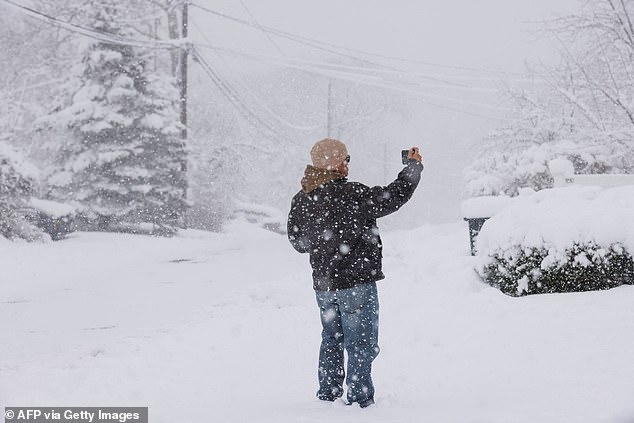 A man takes photos of the storm in Tappan, New York, on Tuesday as the area is flooded with snow