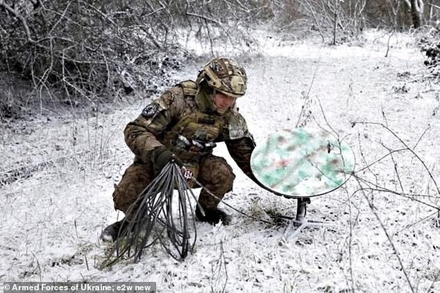 A Ukrainian soldier sets up Starlink satellite equipment