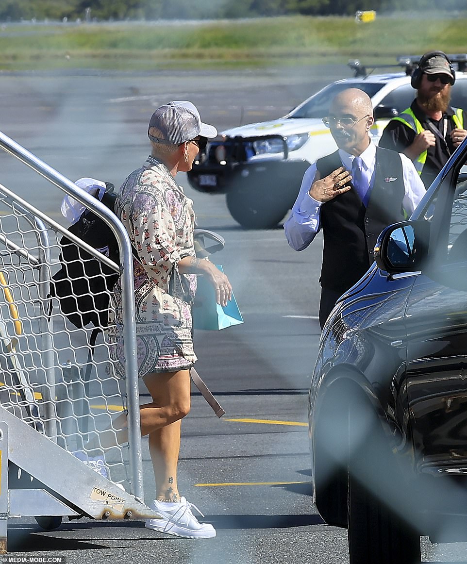 The singer wore a paisley print outfit and a gray trucker cap during the short flight