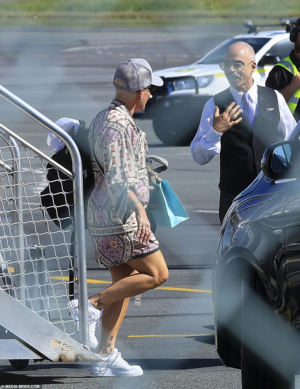 She appeared to smile and have a friendly conversation with an airport employee before turning to walk back up the stairs