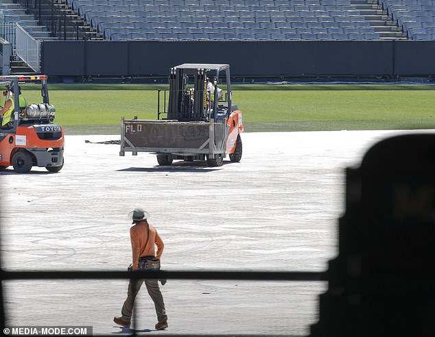 Forklifts carried large structures across the field while huge light stands were pulled into place