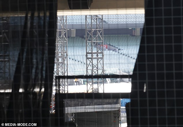 Dozens of empty bleachers surrounded the field as the cat walk was constructed