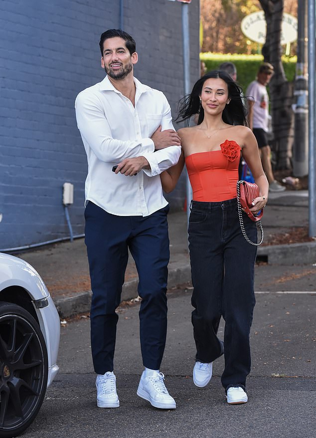 Evelyn, 27, was a vision in red as she showed off her stunning physique in a strapless bustier top which she teamed with chic black trousers