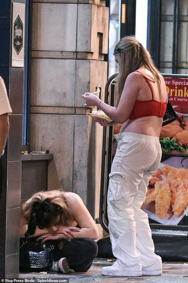 As the night turned to morning and the clubs closed, friends were seen looking out for each other, while one girl enjoyed cheese chips while standing over her friend who was lying on the floor.