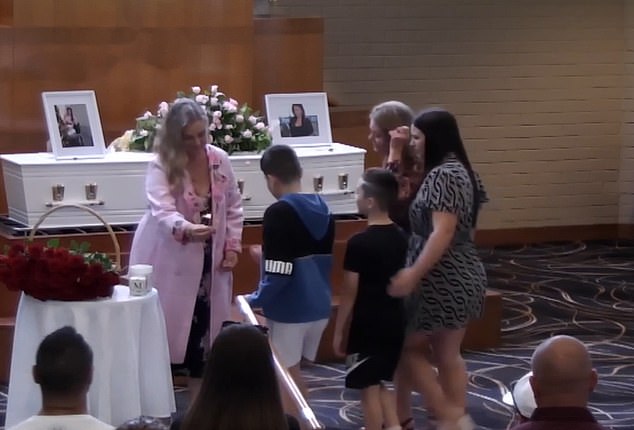 Mrs. Bellamy's two sons were brought to the front of the chapel by their grandmother and aunt at the start of the ceremony to light candles