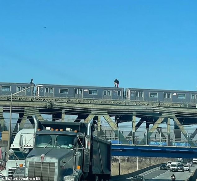 In another photo, the men are seen facing each other as one stood upright and the other crouched.  A third man watches the brutal show as cars and trucks drive beneath the evaluated tracks