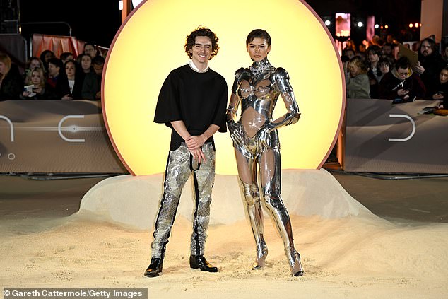 As the pair posed together, the 28-year-old seemed to have missed the memo as he donned silver patterned trousers and a black loose-fitting top.