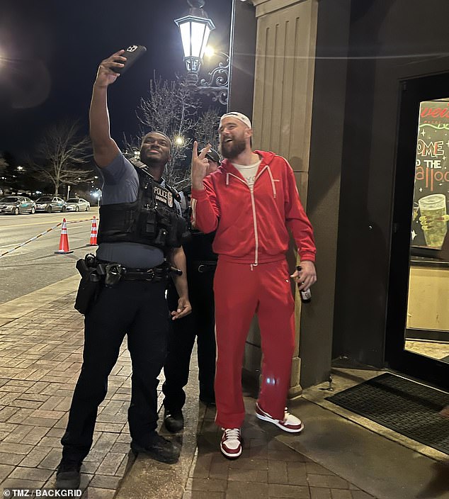 Just hours after 22 fans were shot, Kelce thought it was a great idea to go to 'Granfalloon Restaurant and Bar' and take selfies with police while carrying an open beer bottle on the street, after previously walking to the parade stage had gone and looked far too drunk to speak.