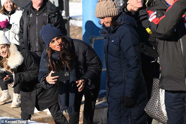 Proud Meghan watched and took videos and photos of Harry as he zoomed to the end of the bobsleigh track