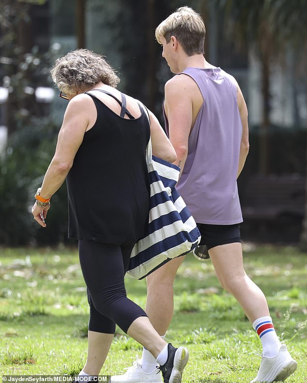 The cookbook author wore a pair of black running shoes while carrying a navy blue and white striped bag