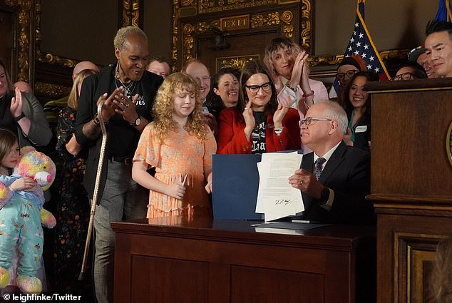 Late last year, Democrat Minnesota Governor Tim Walz signed an executive order protecting the rights of LGBTQ people from Minnesota and other states to receive gender-affirming health care.  Finke is pictured in the background during the signing session