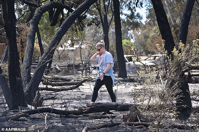 A woman walks through the charred remains of the western Victorian town of Pomonal due to bushfires