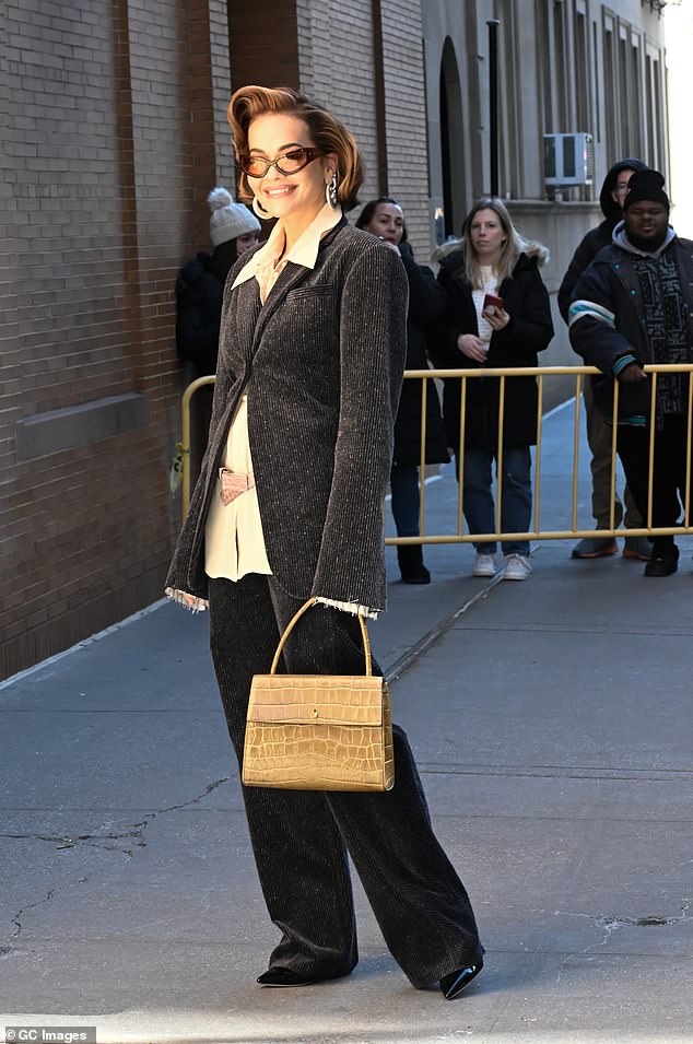 The 33-year-old singer wore a chic charcoal gray pantsuit that she combined with a cream-colored blouse