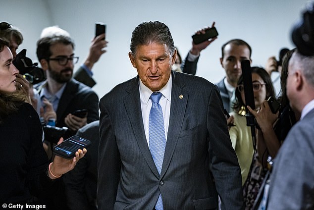 Senator Joe Manchin (D-WV) is surrounded by reporters as he heads to a Senate vote