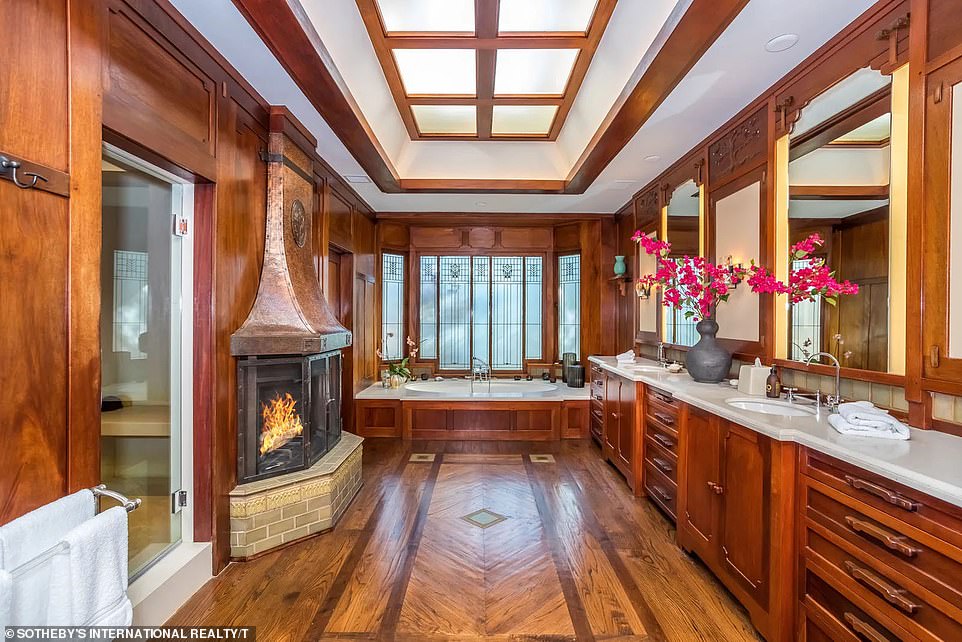 One of the bathrooms has an Old Hollywood vibe, with both wood floors and dark wood paneling, along with a fireplace