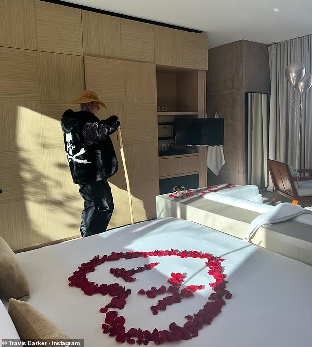 In another photo, Travis was seen preparing their bedroom for Valentine's Day as he scattered red rose petals on the bed, pinning their first name initials in the center of a large heart shape.