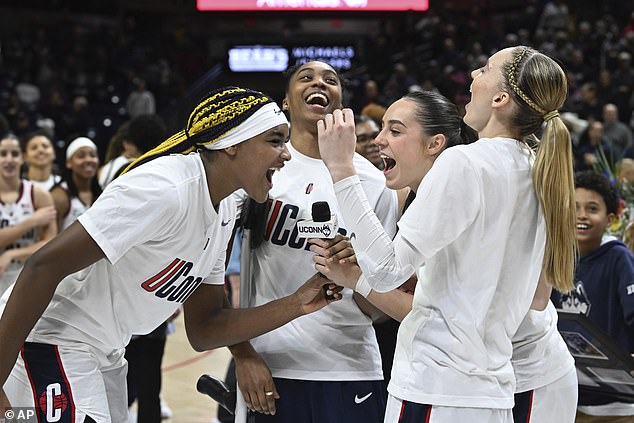 UConn forward Aaliyah Edwards, guard Aubrey Griffin, guard Nika Muhl and guard Paige Bueckers cheer on UConn at the end of senior night ceremonies in Storrs