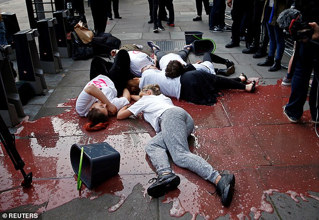 Five members of Extinction Rebellion lay on the 'blood-soaked' sidewalk in front of press photographers in 2019