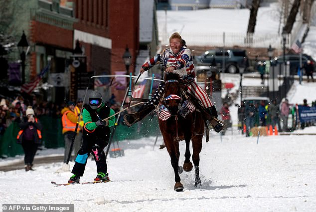 Rider Taylor Stobaugh races down Harrison Avenue as skier and Shawn Gerber navigate the course during the 74th annual Leadville Ski Joring weekend competition on March 5, 2022 in Leadville, Colorado