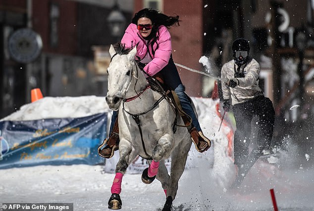 Savannah McCarthy, 23, of Durango, Colorado races down Harrison Avenue on her horse Money as she pulls skier Andrew Borrego during the 75th annual Leadville Ski Joring weekend competition on March 5, 2023 in Leadville, Colorado