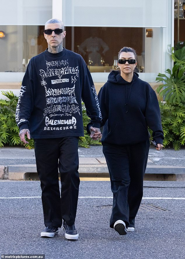 Kardashian wore a dark hoodie with billowy sweatpants, while Barker wore a Balenciaga sweatshirt and dark pants