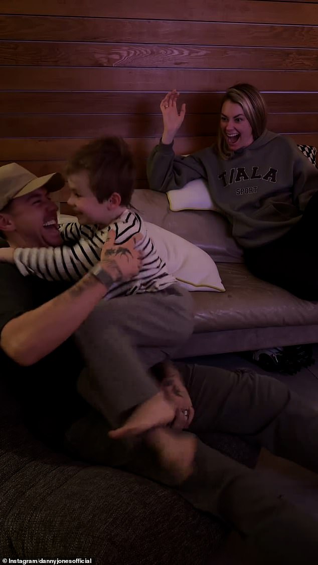 His parents burst out laughing as Cooper jumped off the couch and ran to climb onto his father's lap and hug him