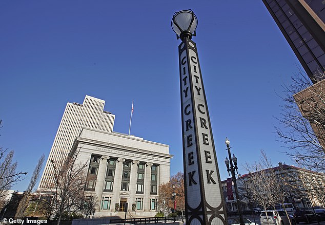 A City Creek Center sign stands across the street from the headquarters of the Church of Jesus Christ of Latter-day Saints in Salt Lake City, Utah