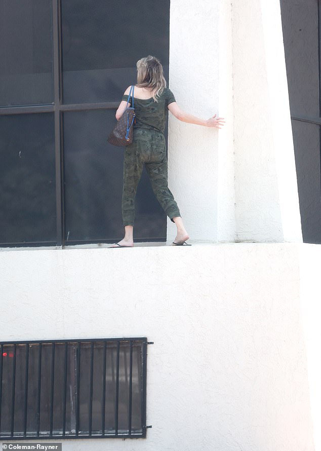 The Melrose Place alum opted to have fiancé Chris Heisser wait in his car and was spotted balancing along the edge of the building last year