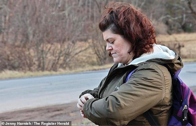 Kolbie's Erin mother checks her watch as she waits for the school bus to arrive