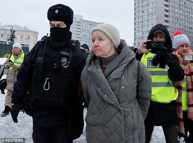 Police officers detain a woman during a rally in memory of Russian opposition leader Alexei Navalny at the Wall of Grief monument to the victims of political repression in Moscow