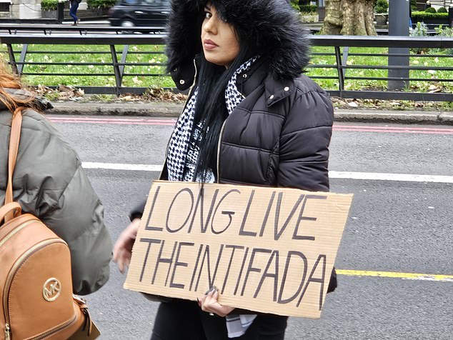 A woman was arrested after she was spotted holding a cardboard sign reading 'Long Live the Intifada'