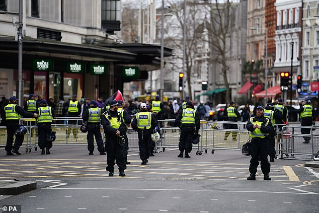 Police officers inside the cordon at the Israeli Embassy in Kensington High Street, London