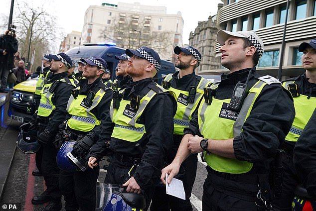 Police officers stand shoulder to shoulder as the march takes place.  About 1,500 officers from all over the country were brought in to maintain order