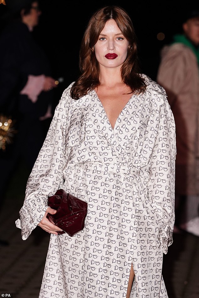 Mick Jagger's daughter increased her height with pointy black heels and carried a small clutch bag while adding a pop of color with a dark red lipstick