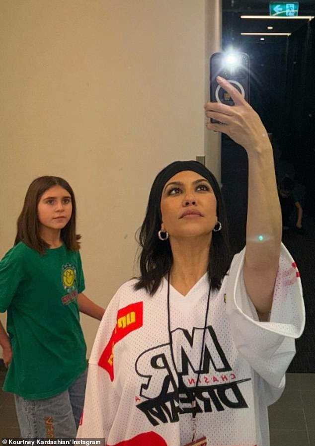 Kourtney showed off her laid-back sense of style in a casual oversized sports tee, which she wore as a dress, as she took a selfie with her daughter Penelope