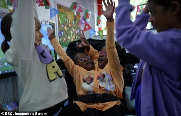 Marieme and Ndeye go to a regular primary school in Cardiff.  They are pictured with their classmates as the group shouts 