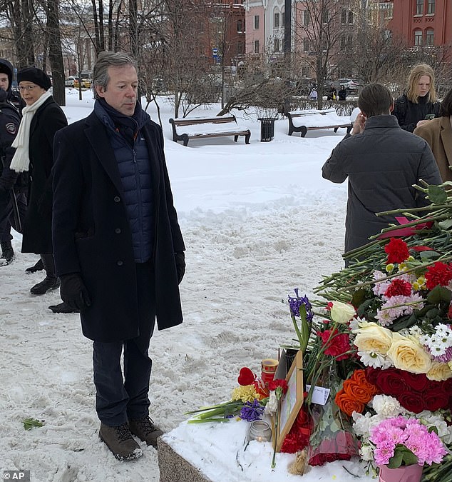 The British ambassador to the Russian Federation stands up after laying flowers to pay his last respects to Alexei Navalny