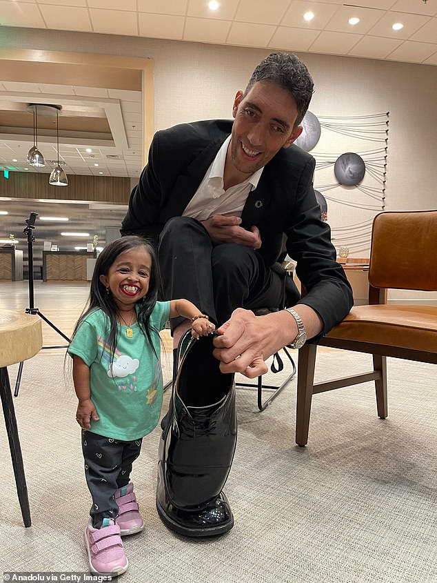 In one of the stunning photos from their reunion six years after meeting in Egypt, Amge stands next to Kosen's shoe and the enormous shoes were almost as tall as she was.