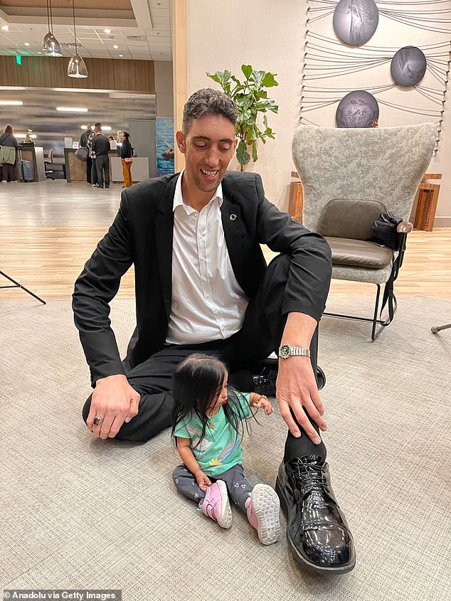 In another extraordinary photo, Amge and Kosen strike the same pose as they sit on the floor with one leg tucked and one leg extended while she was the same height as his knee.