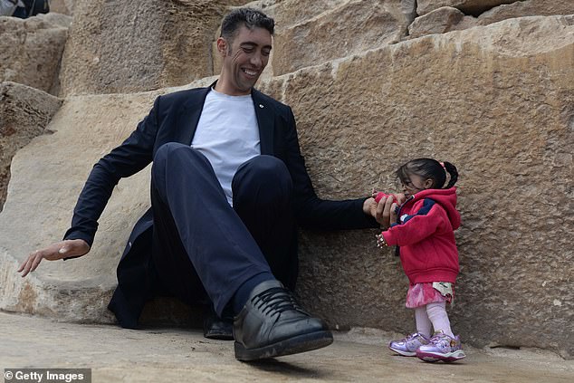 One of yesterday's photos reflects their 2018 photoshoot in Egypt, where Kosen sits on the floor with Amge next to him, but despite his significant decrease in height after sitting down, he still towers over her.