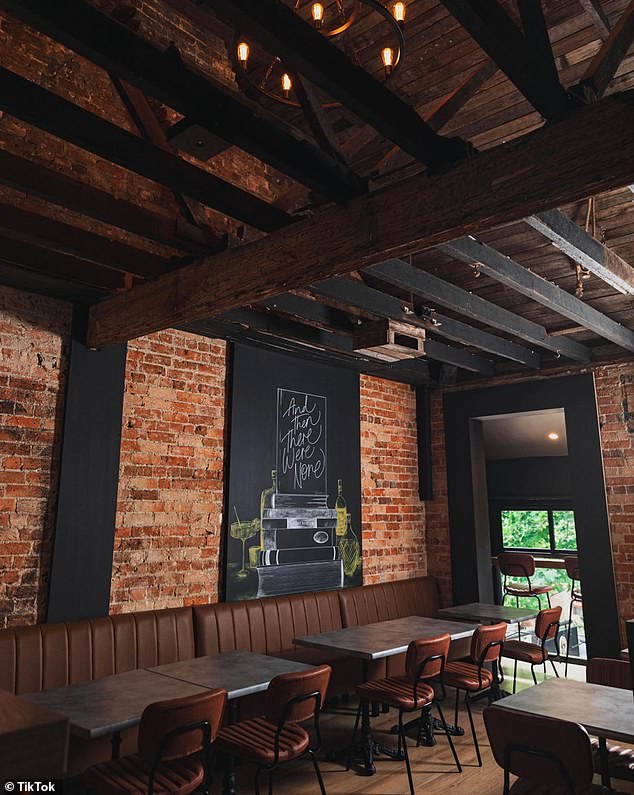 Upon entering, visitors are greeted with a modern and old-world space with exposed dark wood ceiling beams, dimly lit chandeliers and exposed brick walls