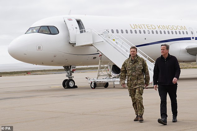 Lord David Cameron (right) arrives at Mount Pleasant Air Base in the Falkland Islands