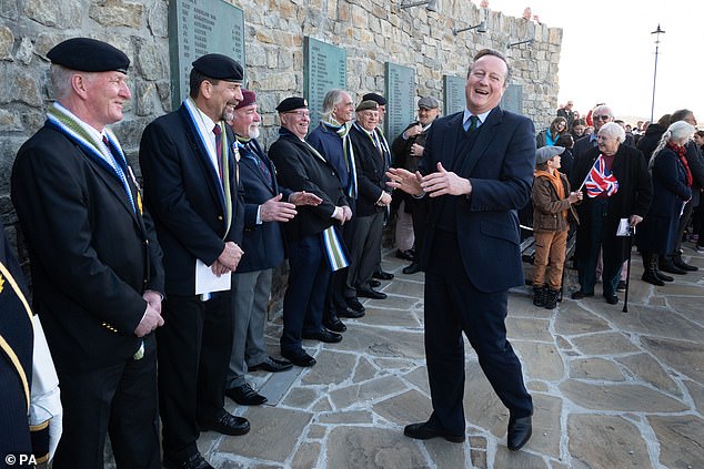 Lord David Cameron (right) attends a wreath-laying ceremony at the Falklands Conflict Memorial in Port Stanley in the Falkland Islands, during his high-profile visit to demonstrate that they are a 