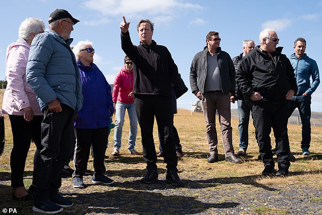 Cameron (centre) meets locals at San Carlos Cemetery in the Falkland Islands, during his high-profile visit