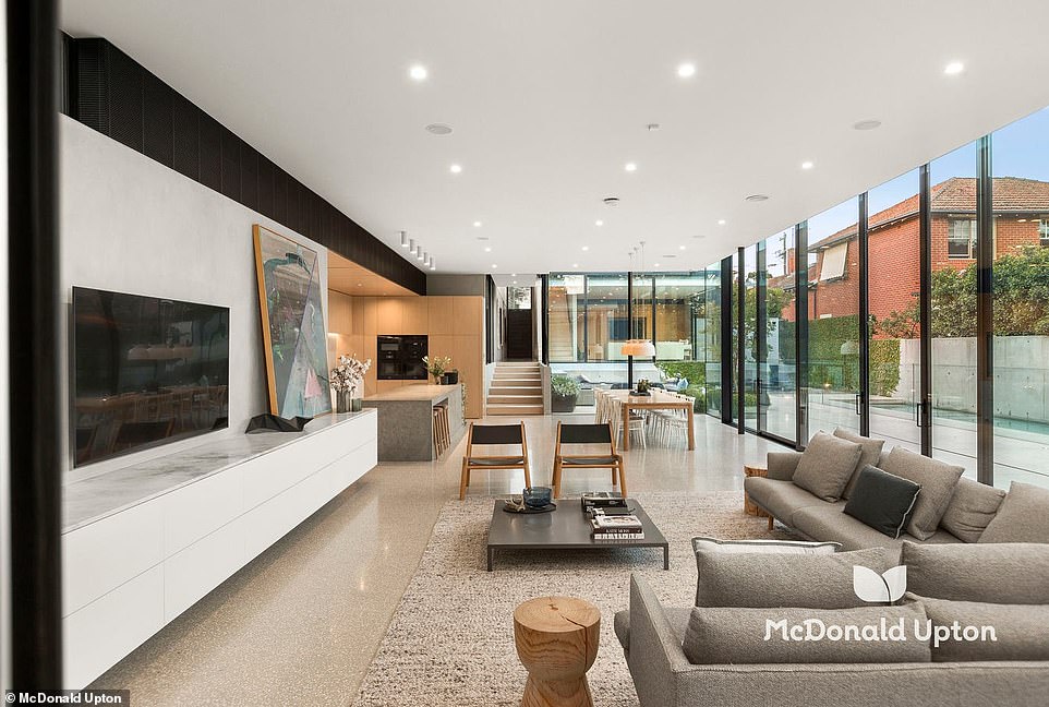 Through the doors is a bright family home with a sleek, minimalist design, glass-enclosed living space, expansive 15-metre swimming pool and Japanese-style courtyards