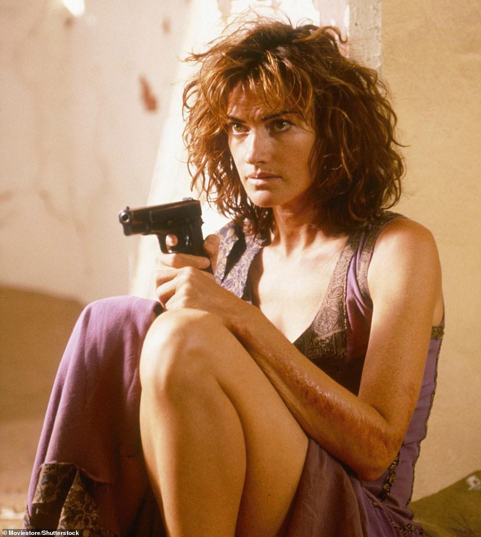 The brunette who appeared in Dust Devil in 1992 holding a gun while wearing a purple dress