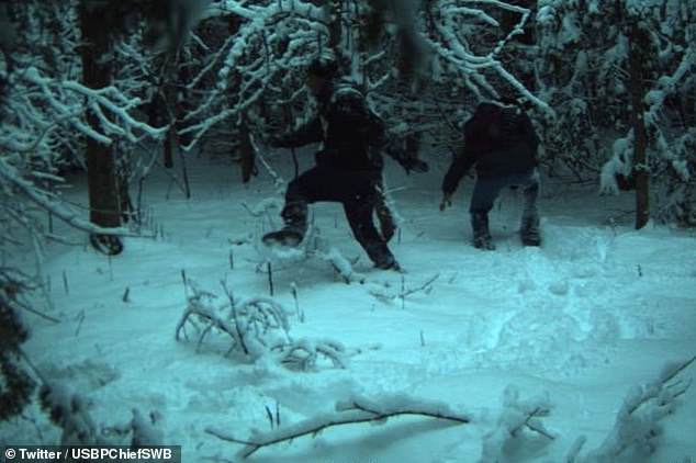 In a photo shared by the Border Patrol, migrants are seen walking through deep snow along the US-Canada border