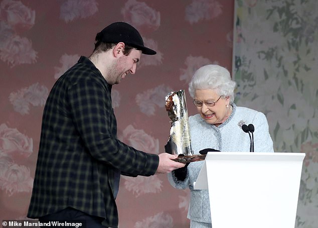 Queen Elizabeth II presents Richard Quinn with the first Queen Elizabeth II Award for British Design on February 20, 2018 in London